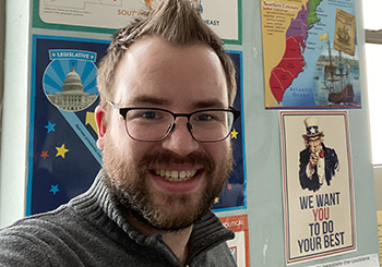 photo of Andrew, smiling, in his high school classroom