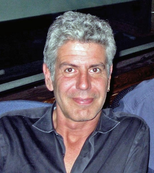 Photo of Anthony Bourdain, seated and smiling at the camera, 2007