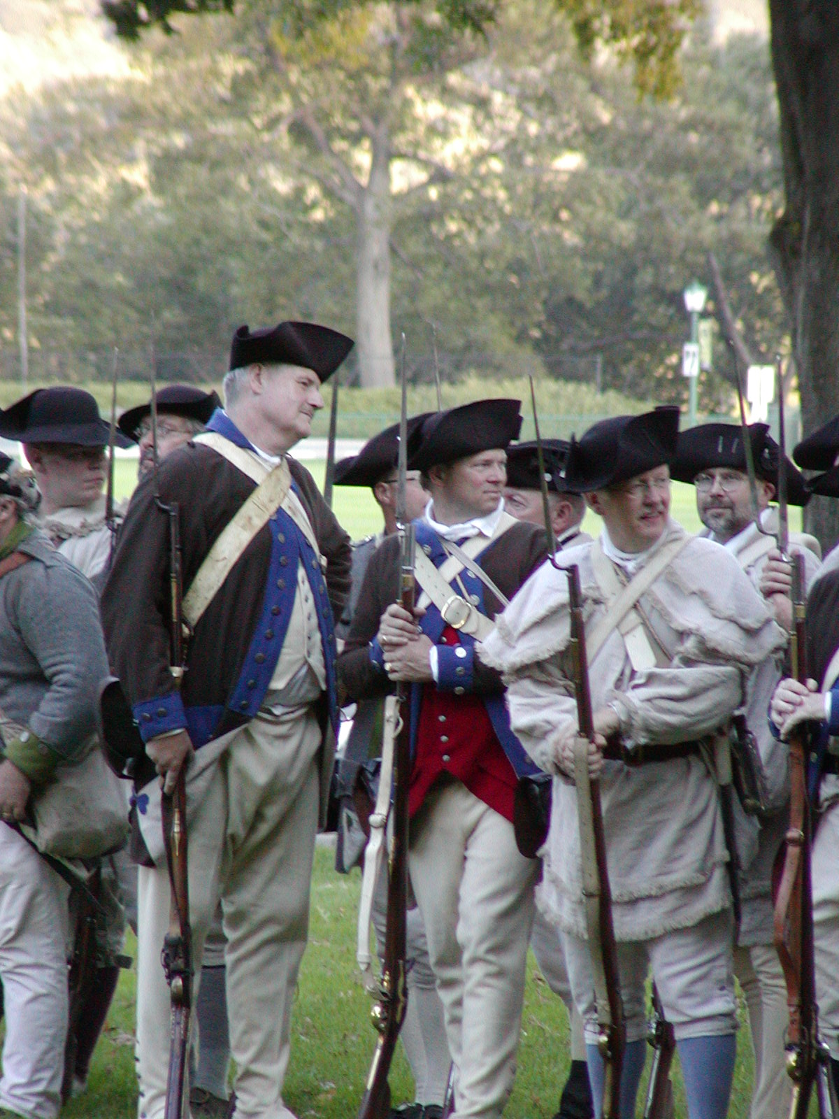 Photo of reenactors at Patriots' Weekend 2002 on the grounds of West Point. They are dressed as 18th c. Colonial troops and carry rifles with bayonets attached.