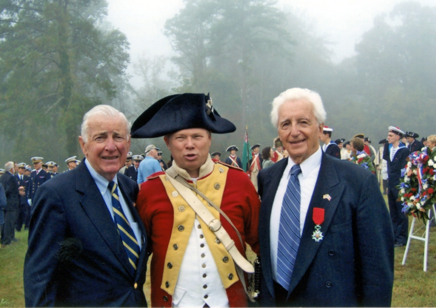 Photo of a reenactor dressed in Continetnal uniform with two men in blue suits