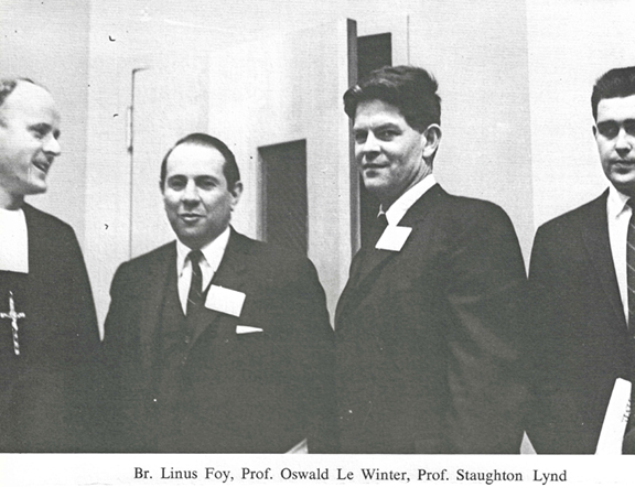 black and white photo of 4 men standing together: Brother Linus Foy, Professor Oswald Le Winter, Professor Staughton Lund, and an unnamed student